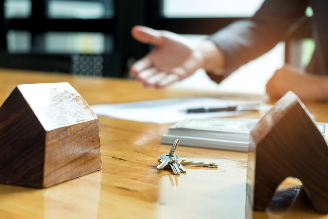 keys waiting to be given over with a handshake | Featured Image For How Much Money Do You Need to Start Investing in Property? blog