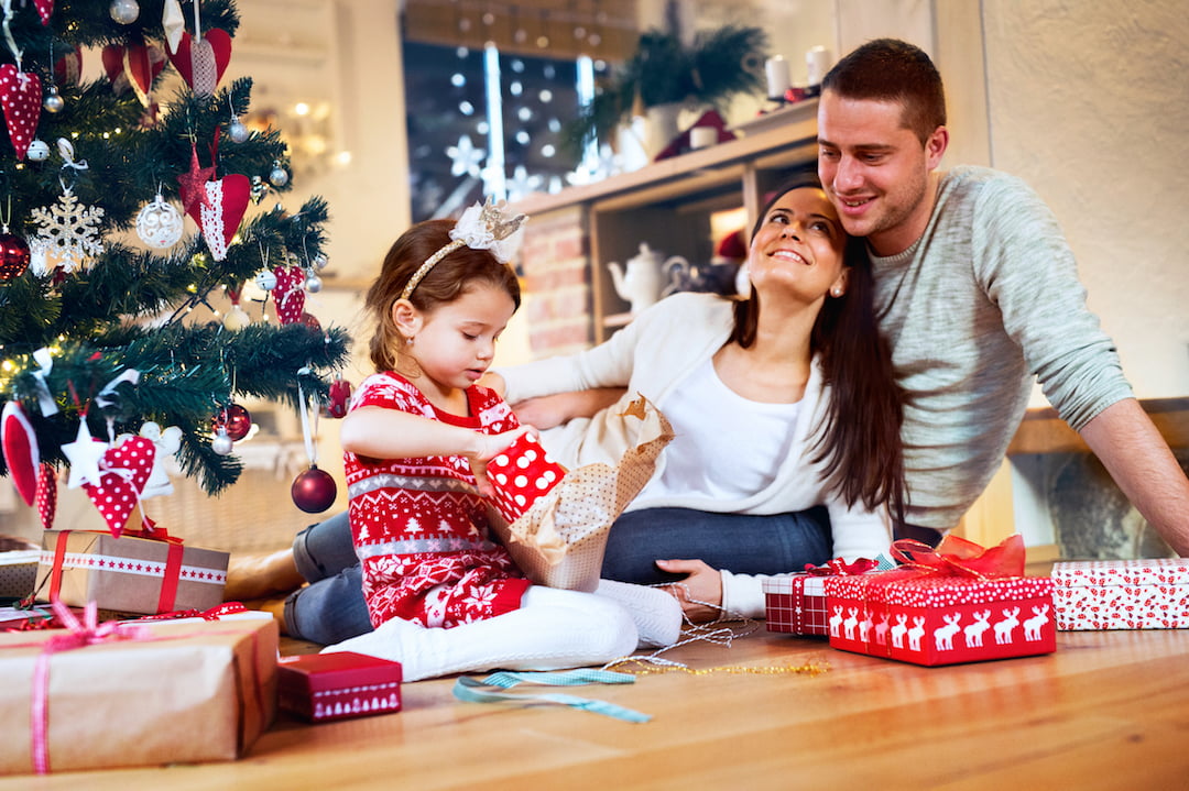 family watching daughter open presents | Featured Image For How You Can Protect Your Credit Rating This Christmas blog