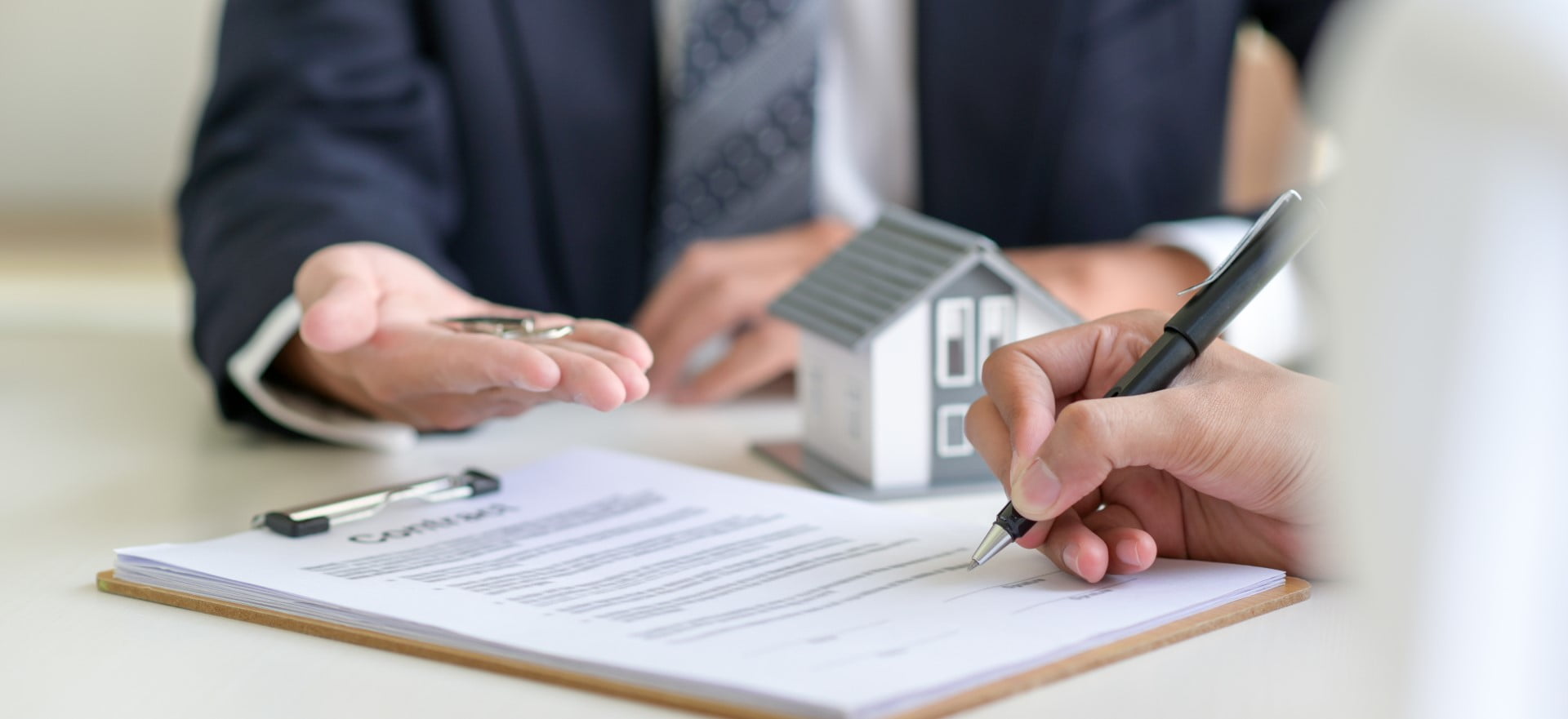 Bank vs Mortgage Broker - Where to Get a Mortgage From Blog Featured Image - Man Signing a Contract on a Home Loan for a Home Purchase