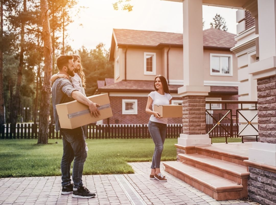 Couple with boxes moving to their new house | Steps to Buying a House for the First Time - Where to Start Blog Featured Image