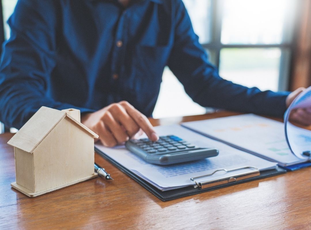 Mortgage broker using calculator | Featured image on Featured image for Buying Your First Home - How to Buy Your First Home Blog